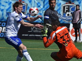 FC Edmonton Daryl Fordyce (16) can't get a foot on the ball as he almost collides with Minnesota United FC goalkeeper Sammy Ndjock (33) in their home-opener during NASL action at Clarke Stadium in Edmonton, April 10, 2016.