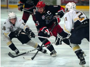 EDMONTON, ALTA: /April/ 17, 2013 -- Bandits' captain Cam Maclise busts through Saints' Cameron Hughes (l) and Carson Soucy in Game 4 of the AJHL final between the Spruce Grove Saints and the Brooks Bandits at theGrant Fuhr Arena, in Spruce Grove, April 17, 2013. (Bruce Edwards/Edmonton Journal)