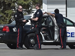Police surround a townhouse in the Cricket Court area in west Edmonton, April 21, 2016.