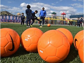 Kids practice at Fuhr Sports Park during a new soccer school with FCBarcelona players on a banner after they announced a new soccer academy for the Edmonton area