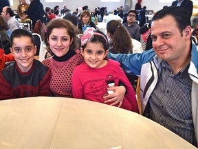 From left: Yousseff Salamah, 13, his mother Jalila, sister Anglina, seven, and father Misheal at a multicultural welcome dinner for new Syrian refugees organized by the Mennonite Centre for Newcomers. The family, who were privately sponsored by a local Mennonite church, arrived here in December.