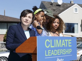 From left, Environment and Parks Minister Shannon Phillips, Ammanuel Aberra, Nia Aberra, 3, and Naomi Aberra during a news conference on Alberta's carbon levy rebates on April 20, 2016.