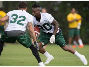 Eskimos' Dillon Baxter (32), left, runs through drills with Joe McKnight (30) during the mini-camp at Historic Dodgertown in Vero Beach on Sunday, April 17, 2016.