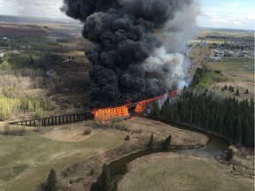 Flames engulf a wooden trestle bridge on the outskirts of Mayerthorpe, Alta., on April 26, 2016.