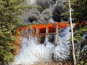 Flames engulf a wooden trestle bridge on the outskirts of Mayerthorpe on Tuesday, April 26, 2016.