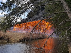 Flames engulf a wooden trestle bridge on the outskirts of Mayerthorpe, Alta. on Tuesday, April 26. 2016.