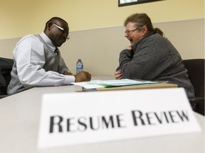 Employment coach Peter Ekekhor (left) gives Karen Chick resume advice during the Resume, Set, Go! Job Search Book Camp at Alberta Works Supports Centre in Edmonton on Monday, April 25, 2016.