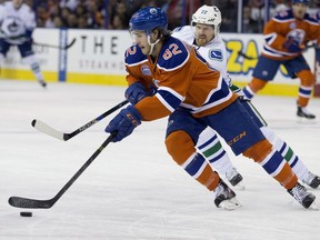 The Edmonton Oilers' Jordan Oesterle (82) battles the Vancouver Canucks' Daniel Sedin (22) during first period NHL action during the last NHL game at Rexall Place, in Edmonton Alta. on Wednesday April 6, 2016.