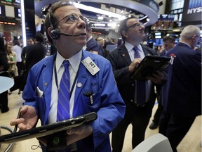 Sal Suarino, left, works with fellow traders on the floor of the New York Stock Exchange, Thursday, April 28, 2016.