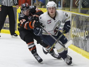 Spruce Grove's Macklin Pichonsky (right) battles Lloydminster's Troy Van Tetering during an AJHL playoff game between the Spruce Grove Saints and the Lloydminster Bobcats at Grant Fuhr Arena in Spruce Grove, Alta., on Friday April 1, 2016.
