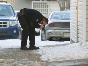 Police investigate at the scene of multiple stabbing along 103 Street north of 107 Avenue, in Edmonton Alta., on Sunday Feb. 22, 2015.
