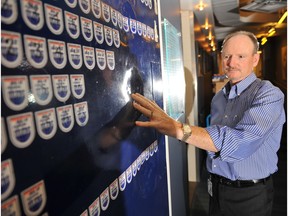 Former Edmonton Oilers equipment manager Barrie Stafford examines the door in the team's dressing room at Rexall place that still shows the dents from the players in the glory days of the franchise.