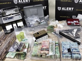 The ALERT police team released this photo Friday showing drugs, guns and paraphernalia seized from seven Edmonton-area homes last month.