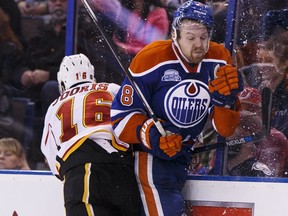 Edmonton's Griffin Reinhart (8) gets hit by Calgary's Josh Jooris (16) during the second period of a NHL game between the Edmonton Oilers and the Calgary Flames at Rexall Place in Edmonton on April 2, 2016.