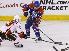 Edmonton's Taylor Hall (4) and Calgary's Jakub Nakladal (33) battle during the third period of a NHL game between the Edmonton Oilers and the Calgary Flames at Rexall Place in Edmonton, Alta., on Saturday April 2, 2016. Photo by Ian Kucerak