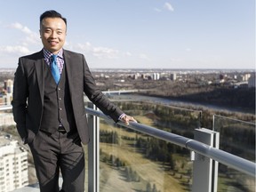 Real-estate agent Jakie Ng poses on the balcony of a two-storey condo at The Pearl tower in Edmonton.