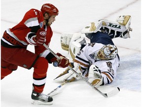 Edmonton Oilers goalie Dwayne Roloson pokes the puck away from Carolina Hurricanes sniper Eric Staal on a breakaway in the second period of Game 1 of the Stanley Cup final on June 5, 2006.