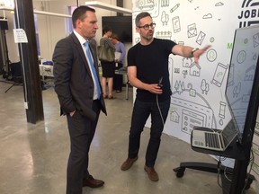 Nick Keyko (right), head of marketing for Edmonton tech firm Jobber, shows the company's work in April 2016 to Alberta Economic Development Minister Deron Bilous.