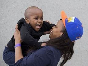 Fort McMurray wildfire evacuee Ebensela Tjaverua holds her son Marcelo Ndjoze, three, outside the evacuation centre at the Edmonton Expo Centre, 7515 118 Ave., in Edmonton, Alta., on Thursday, May 5, 2016.