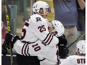 Evan Polei (#10) celebrates a goal with Red Deer teammate Adam Musil.