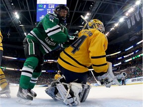 Drake Caggiula of the North Dakota Fighting Hawks and Quinnipiac Bobcats goalie Michael Garteig collide during the championship game of the 2016 NCAA Division I championships at Tampa's Amalie Arena on April 9, 2016. (Getty Images)