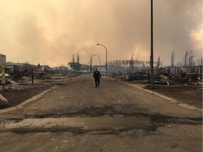 A Mountie surveys the damage on a street in Fort McMurray.