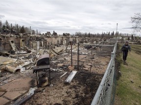 A police officer walks past an apartment complex destroyed in the wildfire in the Abasands neighbourhood in Fort McMurray on  May 9, 2016.