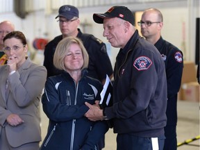 Alberta Premier Rachel Notley  shakes hands with fire chief Darby Allen at the Fort McMurray fire department on May 9, 2016.