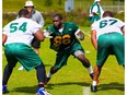 BRADENTON, FL -- Edmonton Eskimos players work out during a mini-camp at MIG Academy in Bradenton, Florida, on Wednesday, April 23, 2014.  (PHOTO / CHIP LITHERLAND) --- Begin Additional Info --- Offensive linemen Selvish Capers, left, and D'Anthony Batiste, right, run a drill with defensive tackle Daniel Ross under the watchful eye of offensive line coach Jonathan Himebauch during the Edmonton Eskimos' mini-camp Wednesday, April 23, 2014, at Bradenton, Fla.