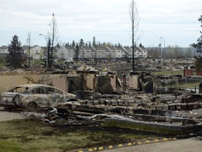 A burned out car and the remains of a house are seen in the Beacon Hill neighbourhood during a media tour of the fire-damaged city of  Fort McMurray on  May 9, 2016.