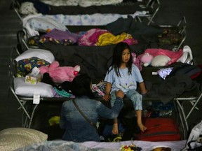 A young girl sits on a cot at a makeshift evacuee center in Lac la Biche  on May 5, 2016.