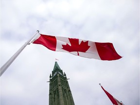 A Canadian flag flies in front of the peace tower on Parliament Hill in Ottawa on Dec. 4, 2015, as part of the ceremonies to the start Canada's 42nd parliament.