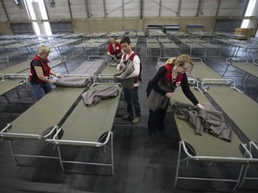 Red Cross volunteers set up cots at the wildfire evacuee centre at the Edmonton Expo Centre on May 6, 2016.