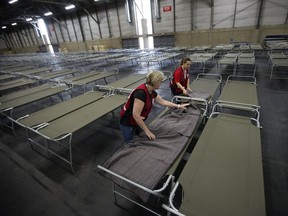 Red Cross volunteers set up cots at the Edmonton Expo Centre.