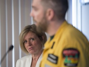 Premier Rachel Notley listens to Chad Morrison of Alberta Wildfire at a news conference to update the status of the numerous Alberta fires.