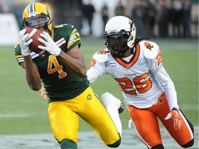 Adarius Bowman of the Edmonton Eskimos, left, hauls in a pass against Cord Parks of the B.C. Lions at Commonwealth Stadium in Edmonton on Nov. 1, 2014.