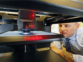 Canadian National Institute for the Blind (CNIB) employee Conor Pilz watches a 3D printer at work in Edmonton on May 26, 2016.