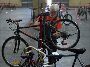 Volunteer Adrian Pearce checks over a bike at the 2015 bike swap.