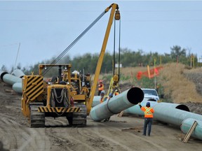 Midwest Construction workers assemble an Enbridge pipeline to Hardisty southeast of New Sarepta in 2014. A new University of Alberta study calculated  greenhouse gas emissions over the lifecycle of a pipeline to determine they are better than railways for getting bitumen to market.