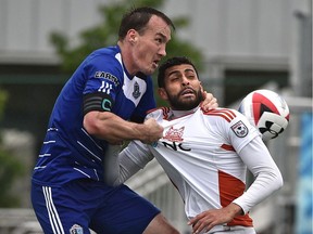 FC Edmonton Albert Watson (5) grabs the neck of Carolina RailHawks Aly Hassan (9) going up for a header during NASL at Clarke Field in Edmonton, May 22, 2016.