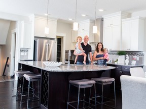 Erik Eisen, an area sales manager with Sterling Homes, in a showhome with wife Jen and daughters Emma and Anika.