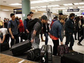 Evacuees from the wildfire in and around Fort McMurray claim their luggage at the Edmonton International Airport in Edmonton, Alta., on May 6, 2016.