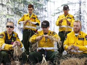 Firefighters learn to make cordage from wilderness survival trainer Kelly Harlton during a bootcamp held near Slave Lake on Wednesday, April 27, 2016 .