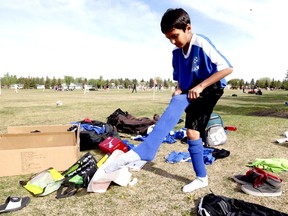Fort McMurray Fury player Aneesh Jhanwar, 10, puts on donated soccer gear during a tournament in Edmonton Saturday, May 7, 2016.