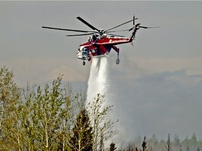 A helicopter battles a wildfire south of Fort McMurray, Alta., on May 8, 2016.