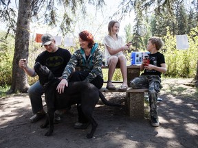 John Davis, his wife Melissa, and their children, Jordyn, 12, and Leyton, 10, play with the family dog, Scooby, at Rainbow Valley Campground in Edmonton, Alta., on May 11, 2016.