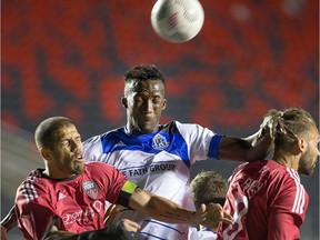 Fury defender Rafael Alves (L) and Edmonton's Pape Diakite (C) go for the ball with Fury player James Bailey (R) in close in the second half as Ottawa Fury FC take on FC Edmonton at TD Place stadium.