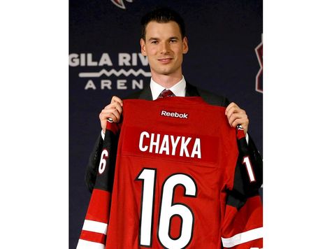 Newly appointed Arizona Coyotes general manager John Chayka holds a game jersey after a news conference announcing his promotion, Thursday, May 5, 2016, in Glendale, Ariz. Chayka is the youngest GM in NHL history.