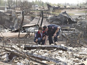 Prime Minister Justin Trudeau, left, and Fort McMurray Fire Chief Darby Allen look over the devastation during a visit to Fort McMurray on Friday, May 13, 2016.