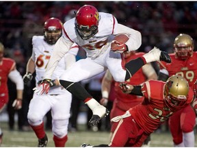 University of Calgary Dinos Mercer Timmis leaps over Laval Rouge et Or Vincent Plante during Vanier Cup action Saturday, November 23, 2013 in Quebec City.